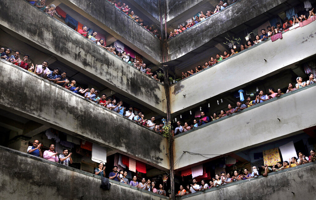 People clap from balconies in a show of appreciation for health care workers in Mumbai, India, Sunday, March 22, 2020. (AP Photo/Rafiq Maqbool)