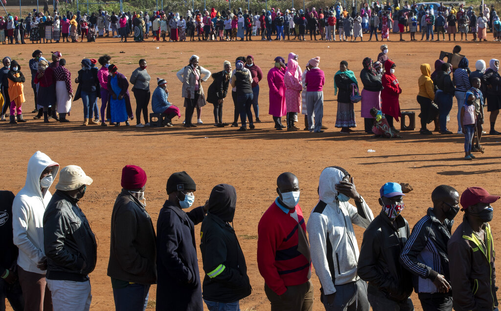 People affected by the coronavirus economic downturn line up to receive food donations at the Iterileng informal settlement near Laudium, southwest of Pretoria, South Africa, Wednesday, May 20, 2020. (AP Photo/Themba Hadebe)