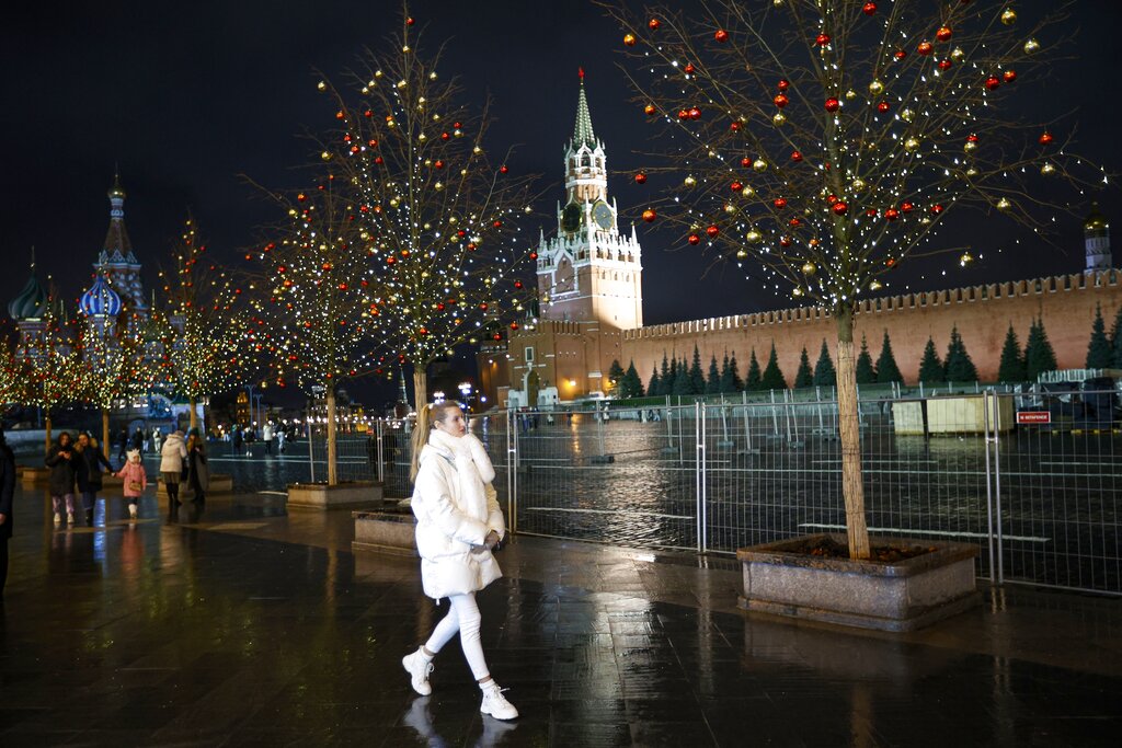 A woman walks along Red Square decorated for Christmas and New Year celebrations and almost empty due to the coronavirus pandemic in Moscow, Russia, Tuesday, Nov. 24, 2020. New Year is the biggest holiday of the year in Russia, and is followed by the Orthodox Christmas on Jan. 7. Russia, which currently has the world's fifth largest number of confirmed cases, has been swept by a rapid coronavirus resurgence since September. (AP Photo/Alexander Zemlianichenko)