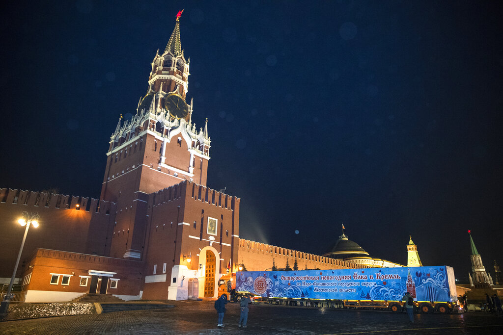 A truck carrying Russia's Main Christmas Tree enters the Kremlin's Spasskaya Tower's gates in Moscow, Russia, Friday, Dec. 11, 2020. A 96 year old 25 meter fit tree with a diameter of 60 centimeters was cut down near the village of Cheblokovo, about 100 km west of Moscow, and will be installed on the the Kremlin's Cathedral Square. (AP Photo/Pavel Golovkin)