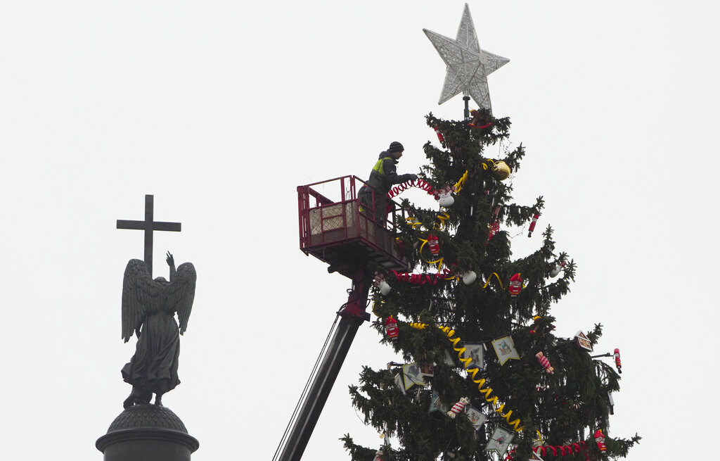 Workers decorate a Christmas tree at the Palace square in St.Petersburg, Russia, Saturday, Dec. 19, 2020. (AP Photo/Dmitri Lovetsky)