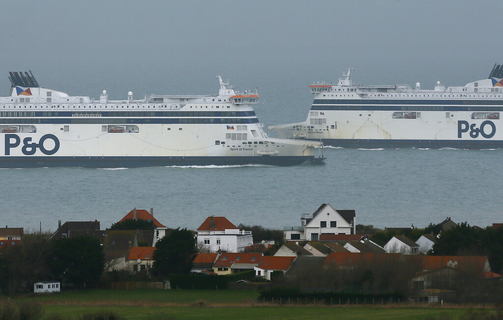 The ferry, left, arriving from the Port of Dover in southern England, loaded with trucks, arrives at the port of Calais in northern France, Tuesday Dec. 22, 2020, while the other one is heading toward Dover. France is banning all travel from the U.K. for 48 hours in an attempt to make sure that a new strain of the coronavirus in Britain doesn't reach its shores. (AP Photo/Michel Spingler)