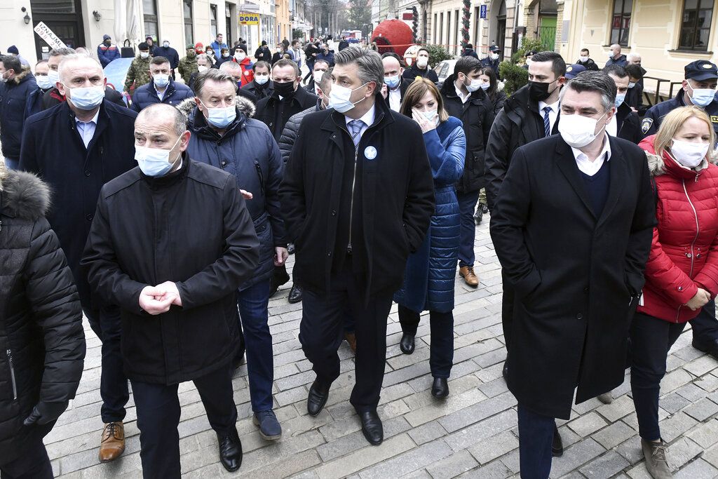 Croatian Prime minister Andrej Plenkovic, center and President Zoran Milanovic, right, inspect damage caused by an earthquake in Sisak, Croatia, Monday, Dec. 28, 2020. A moderate earthquake has hit central Croatia near its capital of Zagreb, triggering panic and some damage south of the city. There were no immediate reports of injuries. (AP Photo)