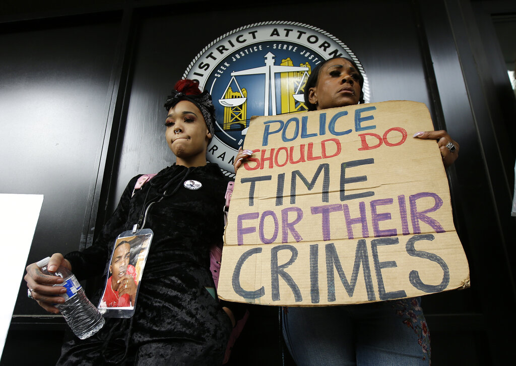 FILE - In this April 4, 2018, file photo, protesters stand outside the office of Sacramento County District Attorney Anne Marie Schubert calling for the indictment of two Sacramento police officers in the shooting death of Stephon Clark, during a rally in Sacramento, Calif. The shooting death of Clark helped spur the passage of two laws to take effect in 2020 giving California one of the nation's most comprehensive approaches to deterring shootings by police. One changes the legal standard for when police can use deadly force, while the companion law increased officers' training on how to handle confrontations. (AP Photo/Rich Pedroncelli, File)