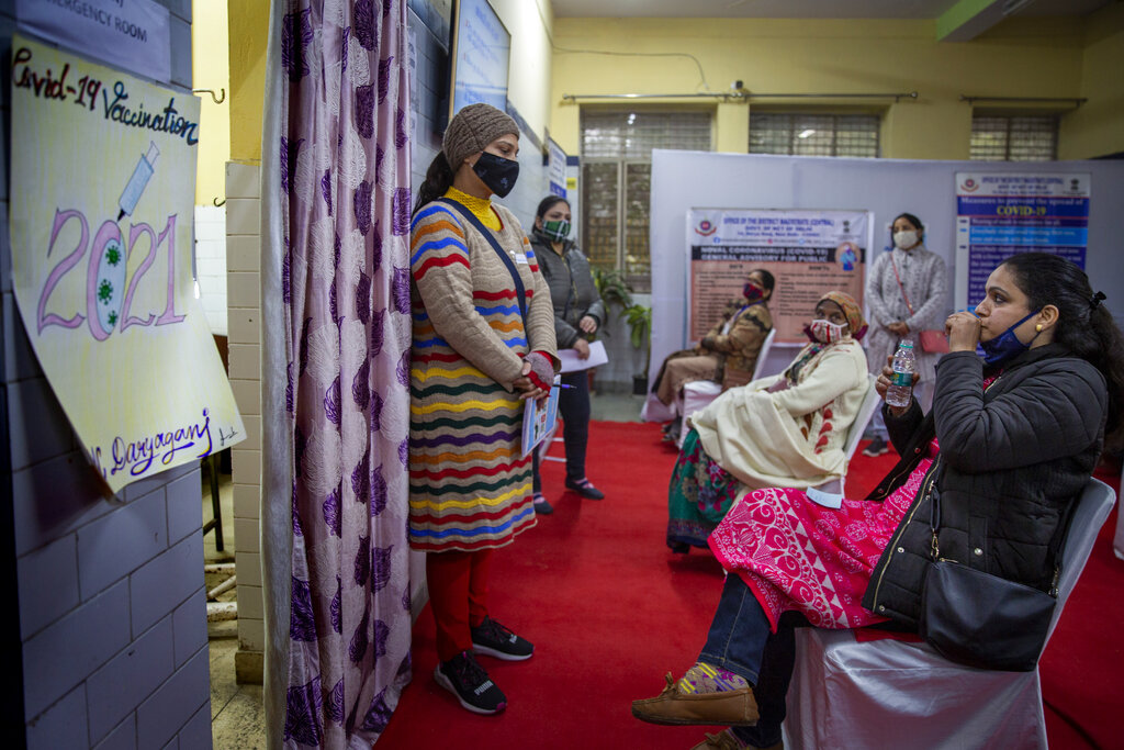 A health worker, left, speak with people participating in a COVID-19 vaccine delivery system trial in New Delhi, India, Saturday, Jan. 2, 2021. India tested its COVID-19 vaccine delivery system with a nationwide trial on Saturday as it prepares to roll-out an inoculation program to stem the coronavirus pandemic. Saturday’s exercise included necessary data entry into an online platform for monitoring vaccine delivery, along with testing of cold storage and transportation arrangements for the vaccine, the health ministry had said.(AP Photo/Altaf Qadri)
