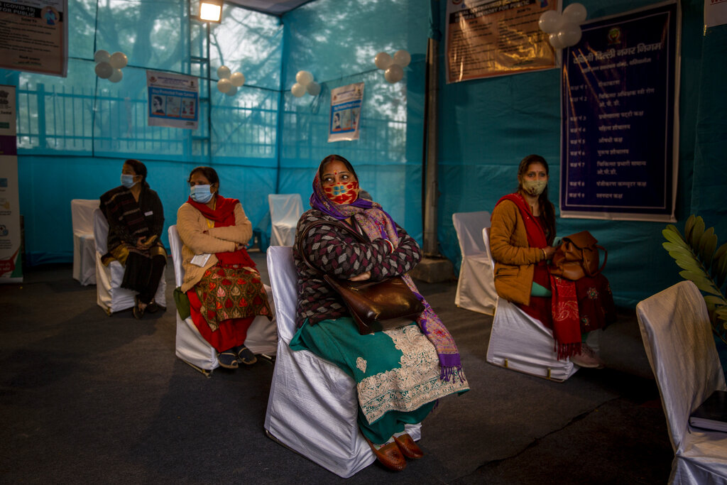 People participating in a COVID-19 vaccine delivery system trial wait for their turn at a COVID-19 vaccination center in New Delhi, India, Saturday, Jan. 2, 2021. India tested its COVID-19 vaccine delivery system with a nationwide trial on Saturday as it prepares to roll-out an inoculation program to stem the coronavirus pandemic. Saturday's exercise included necessary data entry into an online platform for monitoring vaccine delivery, along with testing of cold storage and transportation arrangements for the vaccine, the health ministry had said. (AP Photo/Altaf Qadri)