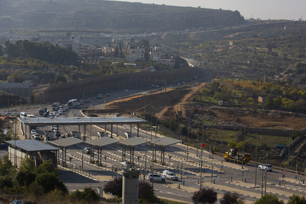 FILE - In this Sunday, Nov. 29, 2020. file photo, roadworks expand a road to Israeli settlements inside the West Bank, near the city of Bethlehem. Israel's premier human rights group has begun describing both Israel and its control of the Palestinian territories as a single 