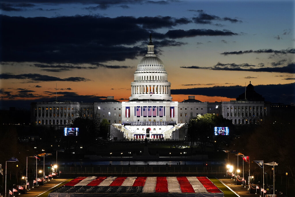 Capitol Building and stage for the swearing-in is lit as events get underway for President-elect Joe Biden's inauguration ceremony, Wednesday, Jan. 20, 2021, in Washington. (AP Photo/Julio Cortez)