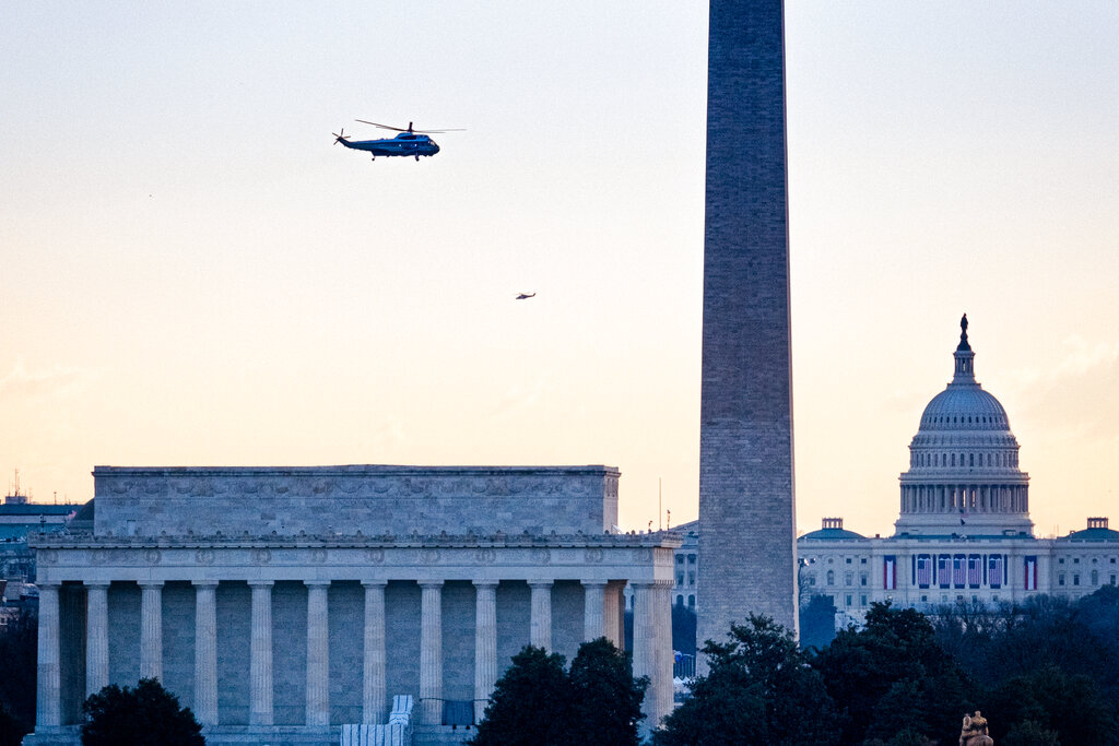 Marine One carrying President Donald Trump flies past the Lincoln Memorial, Washington Monument and the U.S. Capitol as he departs the White House for the final time as President, Wednesday, Jan. 20, 2021. (AP Photo/J. David Ake)