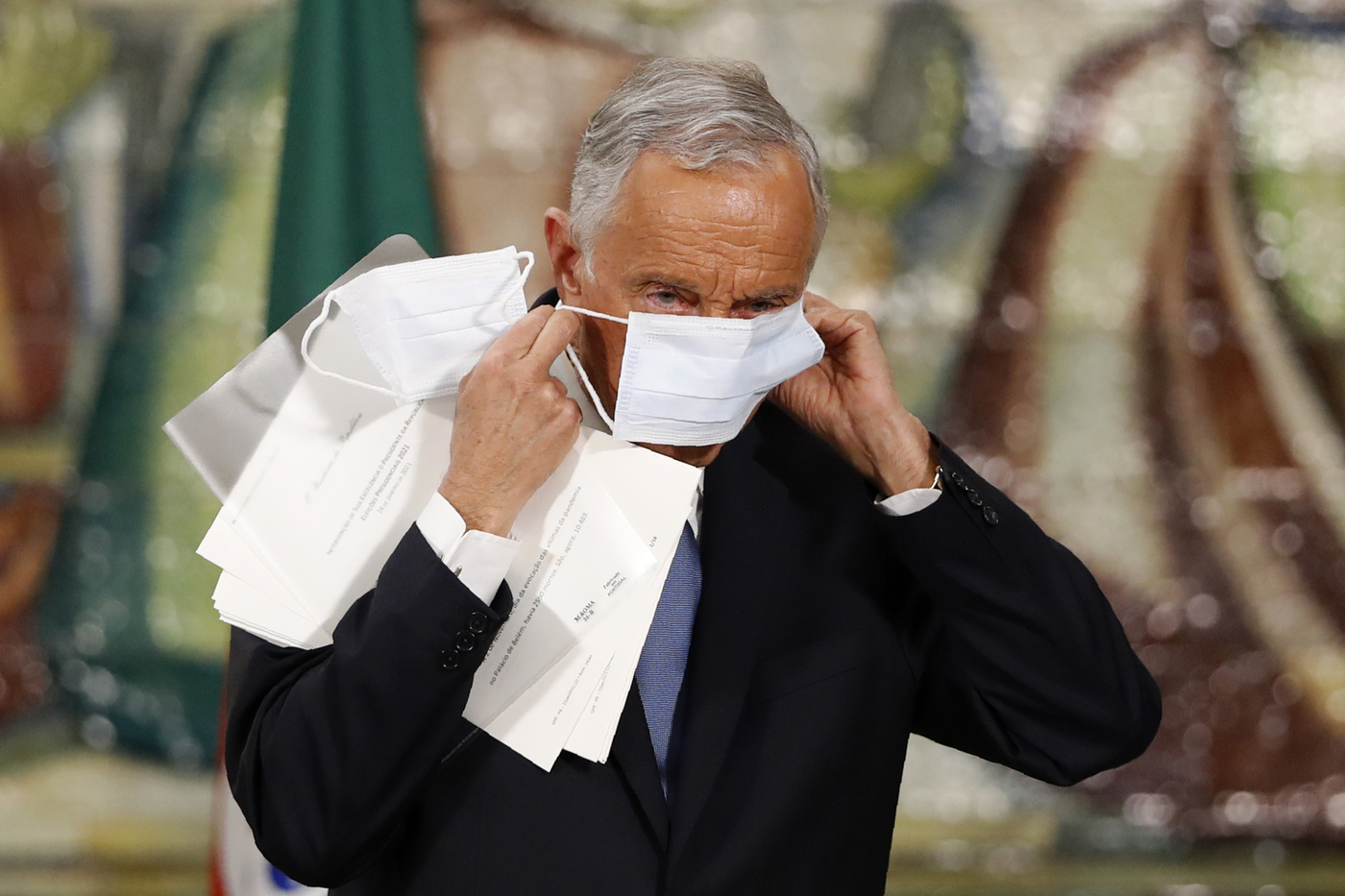 Incumbent Marcelo Rebelo de Sousa puts on his face mask after delivering a speech following the results of Portugal's presidential election in Lisbon, Monday, Jan. 25, 2021. Rebelo de Sousa was reelected for a second five-year term. (AP Photo/Armando Franca)