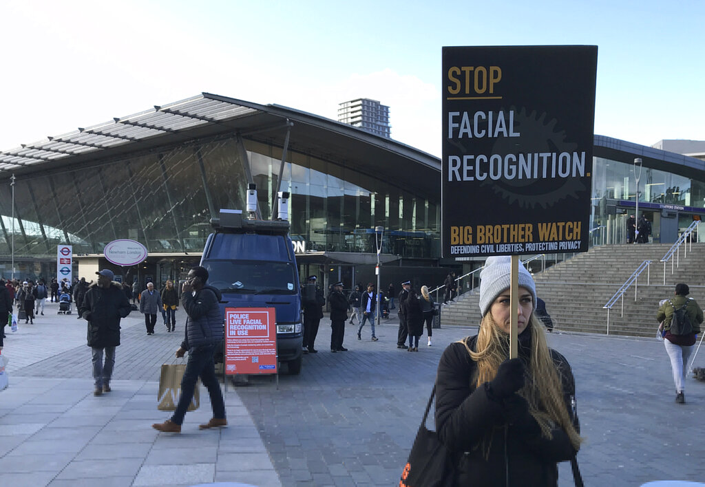 Rights campaigner Silkie Carlo demonstrates in front of a mobile police facial recognition facility outside a shopping centre in London Tuesday Feb. 11, 2020, “We don't accept this. This isn't what you do in a democracy,