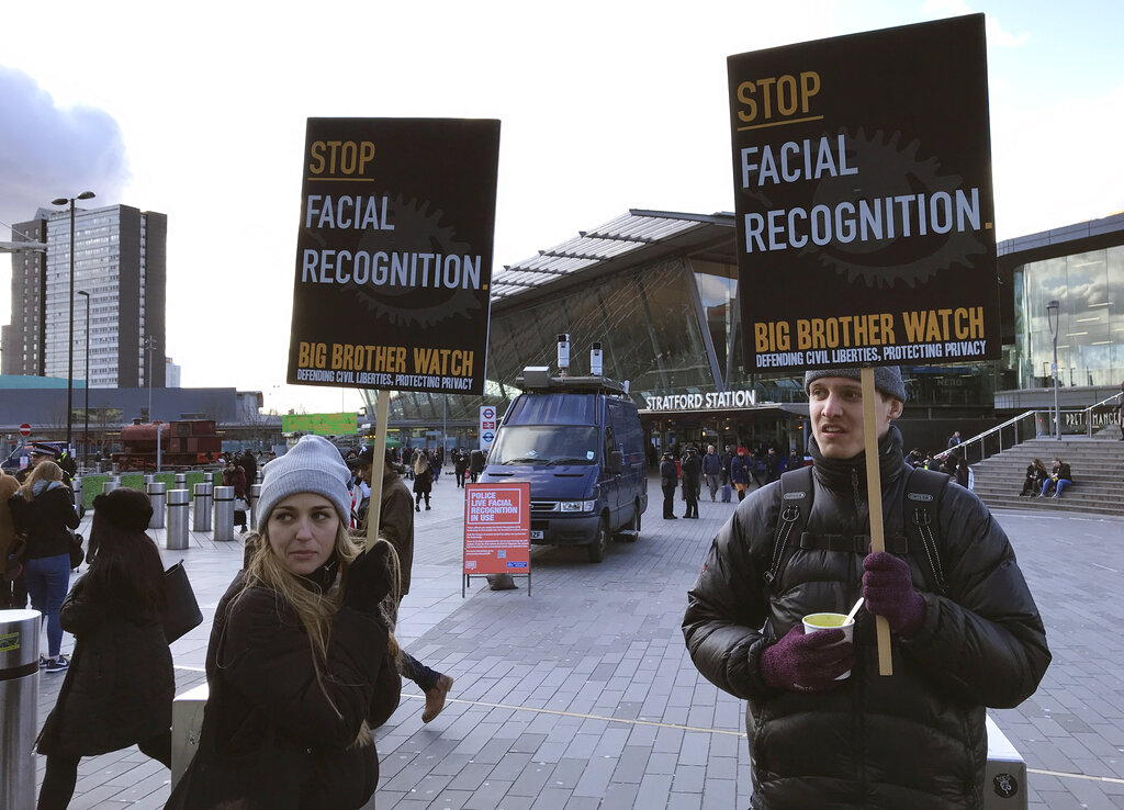 FILE - In this Feb. 11, 2020, file photo, Silkie Carlo, left, demonstrates in front of a mobile police facial recognition facility outside a shopping centre in London. A Black man who says he was unjustly arrested because facial recognition technology mistakenly identified him as a suspected shoplifter is calling for a public apology from Detroit police. And for the department to abandon its use of the controversial technology. (AP Photo/Kelvin Chan, File)