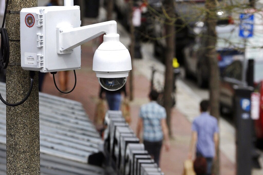 FILE - In this April 14, 2014, file photo, a surveillance camera is attached to a light pole along Boylston Street in Boston. The Boston City Council voted unanimously, Wednesday, June 24, 2020, to pass a ban on the use of facial recognition technology by city government. The push against the technology is being driven both by privacy concerns and after several studies have shown current face-recognition systems are more likely to err when identifying people with darker skin. (AP Photo/Steven Senne, File)