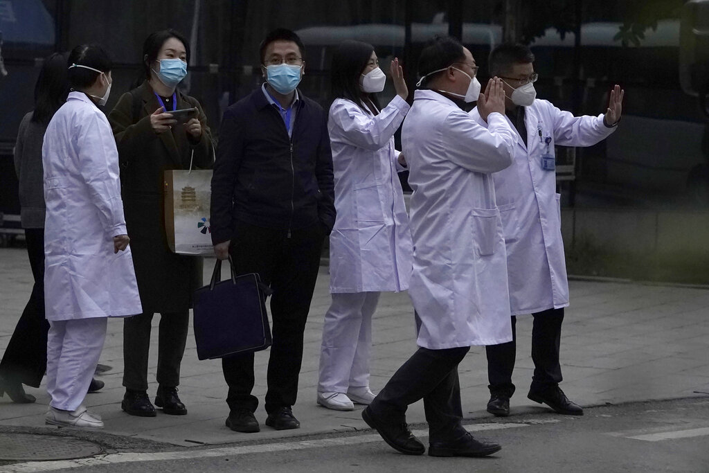 Chinese medical staff wave farewell to a World Health Organization team during their visit to the Hubei Provincial Hospital of Integrated Chinese and Western Medicine also know as the Hubei Province Xinhua Hospital in Wuhan in central China's Hubei province on Friday, Jan. 29, 2021. The World Health Organization team on Friday visited the hospital where China says the first COVID-19 patients were treated more than a year ago as part of the experts' long-awaited fact-finding mission on the origins of the coronavirus. (AP Photo/Ng Han Guan)