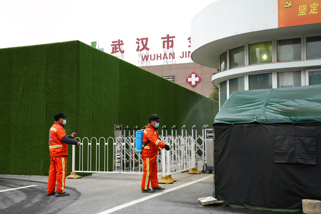 Municipal workers disinfect an entrance of the Wuhan Jinyintan Hospital as the World Health Organization team makes a visit in Wuhan in central China's Hubei province on Saturday, Jan. 30, 2021. The World Health Organization team investigating the origins of the coronavirus pandemic visited another Wuhan hospital that had treated early COVID-19 patients on their second full day of work on Saturday. (AP Photo/Ng Han Guan)