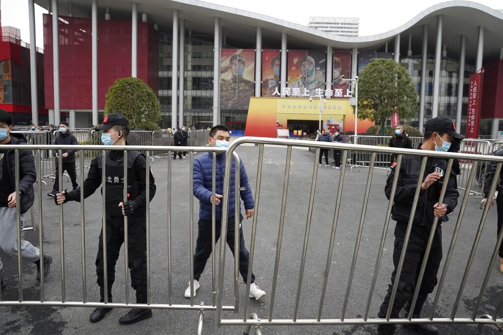 Chinese security personnel move barricades after the World Health Organization team arrived at an exhibition about the fight against the coronavirus in Wuhan in central China's Hubei province on Saturday, Jan. 30, 2021. The World Health Organization team investigating the origins of the coronavirus pandemic visited another Wuhan hospital that had treated early COVID-19 patients on their second full day of work on Saturday. (AP Photo/Ng Han Guan)