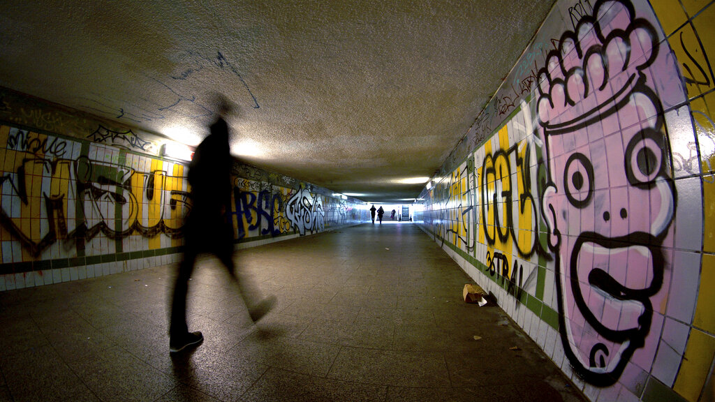 A person walks through a pedestrian subway were the walls are covered with graffiti in Berlin, Germany, Monday, Feb. 1, 2021. (AP Photo/Michael Sohn)