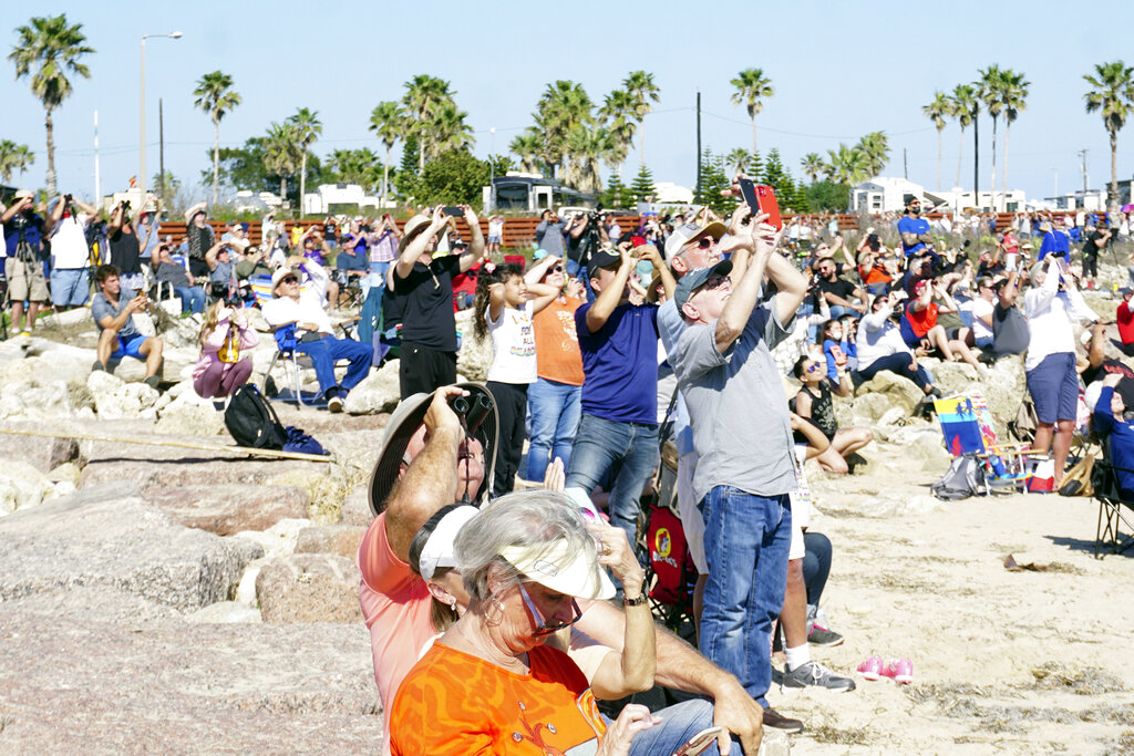 Spectators at Isla Blanca Park on South Padre Island, Texas, look up for a glimpse of SpaceX's bullet-shaped Starship prototype during a test launch, Tuesday, Feb. 2, 2021. The test flight ended in a fiery crash when the Starship attempted to land. (Miguel Roberts/The Brownsville Herald via AP)