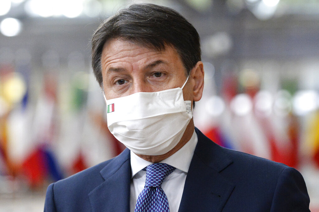 Italy's Prime Minister Giuseppe Conte speaks with the media as he arrives for an EU summit in Brussels, Friday, Oct. 16, 2020. European Union leaders meet for the second day of an EU summit, amid the worsening coronavirus pandemic, to discuss topics on foreign policy issues. (Johanna Geron, Pool via AP)