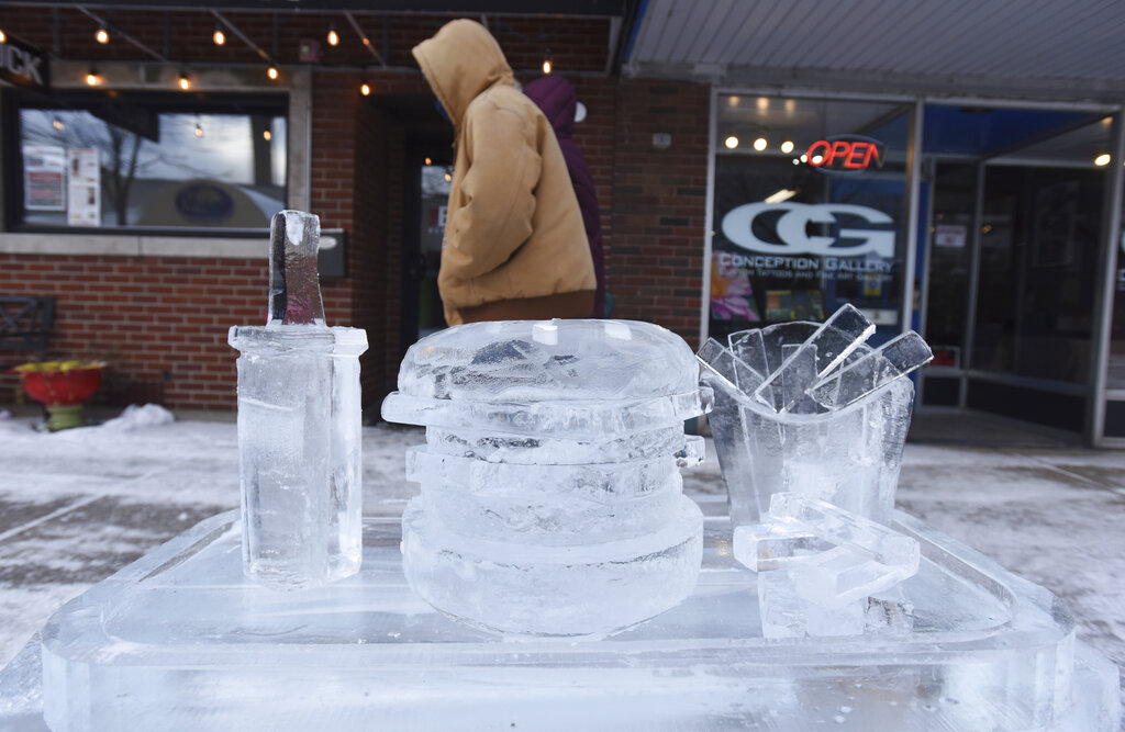 Ice carvers show off their work during the start of The 2021 Magical Ice Fest, Friday, Feb. 5, 2021, held in downtown St. Joseph, Mich. (Don Campbell/The Herald-Palladium via AP)