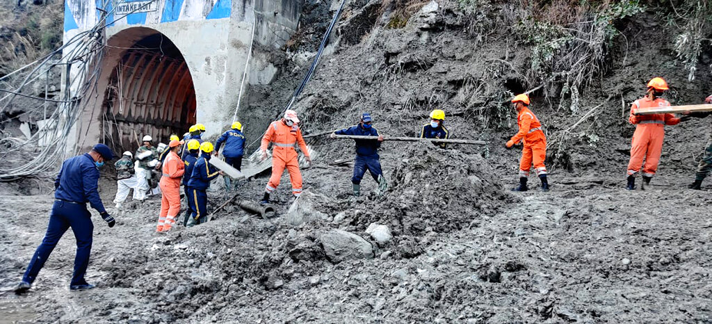 This photograph provided by National Disaster Response Force shows NDRF personnel prepare to rescue workers at one of the hydropower project at Reni village in Chamoli district of Indian state of Uttrakhund, Monday, Feb. 8, 2021. Rescue efforts continued on Monday to save 37 people after part of a glacier broke off, releasing a torrent of water and debris that slammed into two hydroelectric plants on Sunday. (National Disaster Response Force via AP)