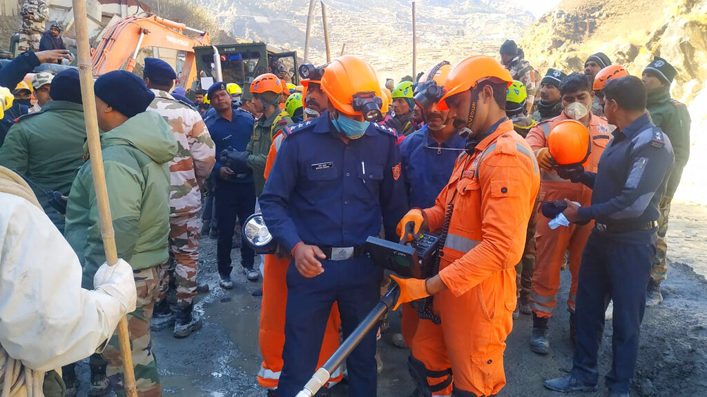 This photograph provided by National Disaster Response Force (NDRF) shows NDRF personnel search for more than three dozen power plant workers trapped in a tunnel after part of a Himalayan glacier broke off Sunday and sent a wall of water and debris rushing down the mountain in Tapovan area of the northern state of Uttarakhand, India, Monday, Feb.8, 2021. (National Disaster Response Force via AP)