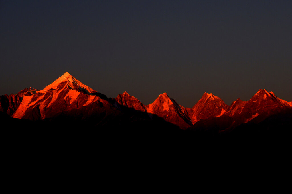 Rays of the setting sun fall on the Panchachuli, a group of five snow-capped Himalayan peaks in Munsiyari, in the Indian state of Uttrakhund, Oct. 28, 2020. Scientists believe that last weekend's glacier disaster in northern India is linked to a landslide and an avalanche. Experts say that the disaster underscores the fragility of the Himalayan mountains where the lives of millions are being altered by climate change. (AP Photo/Manish Swarup)
