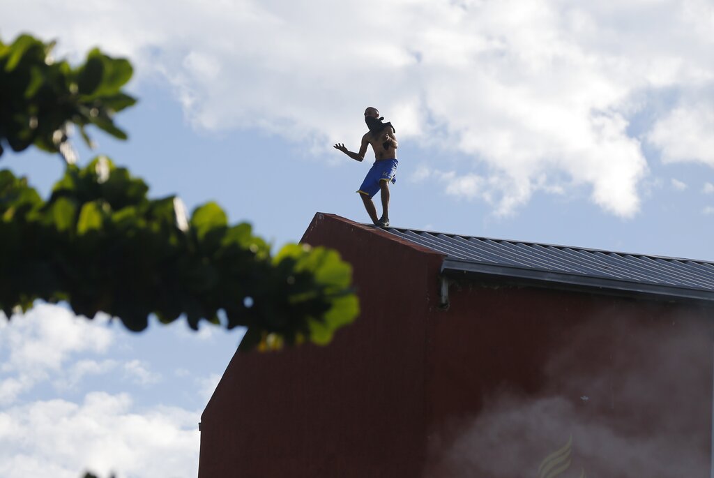 An inmate walks on the roof of Tacumbu prison after they rioted and took control of the place in Asuncion, Paraguay, Tuesday, Feb. 16, 2021. (AP Photo/Jorge Saenz)