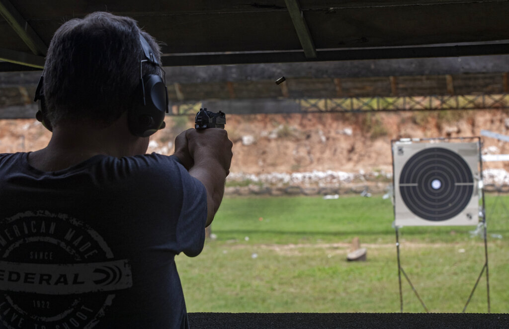 A man practices at a shooting range in Americana, Brazil, Wednesday, Feb. 24, 2021. The debate over private gun ownership has heated up after President Jair Bolsonaro issued decrees to loosen restrictions on the right of private citizens to own weapons. Most Brazilians are in favor of strict laws against gun ownership, but an important minority insist gun rights should be expanded for personal protection and private use. (AP Photo/Andre Penner)