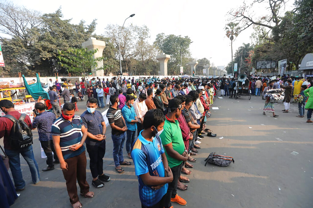 Protesters offer Friday prayers as they protest the death in prison of a writer who was arrested on charges of violating the sweeping digital security, in Dhaka, Bangladesh, Friday, Feb. 26, 2021. Mushtaq Ahmed, 53, was arrested in Dhaka in May last year for making comments on social media that criticized the Prime Minister Sheikh Hasina government's handling of the coronavirus pandemic. He had been denied bail at least six times. (AP Photo/Mahmud Hossain Opu)