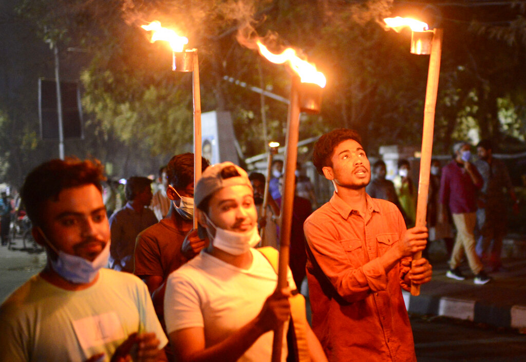 Demonstrators participate in a torch light vigil to protest the death in prison of a writer who was arrested on charges of violating the sweeping digital security, in Dhaka, Bangladesh, Friday, Feb. 26, 2021. Mushtaq Ahmed, 53, was arrested in Dhaka in May last year for making comments on social media that criticized the Prime Minister Sheikh Hasina government's handling of the coronavirus pandemic. He had been denied bail at least six times. (AP Photo/Mahmud Hossain Opu)