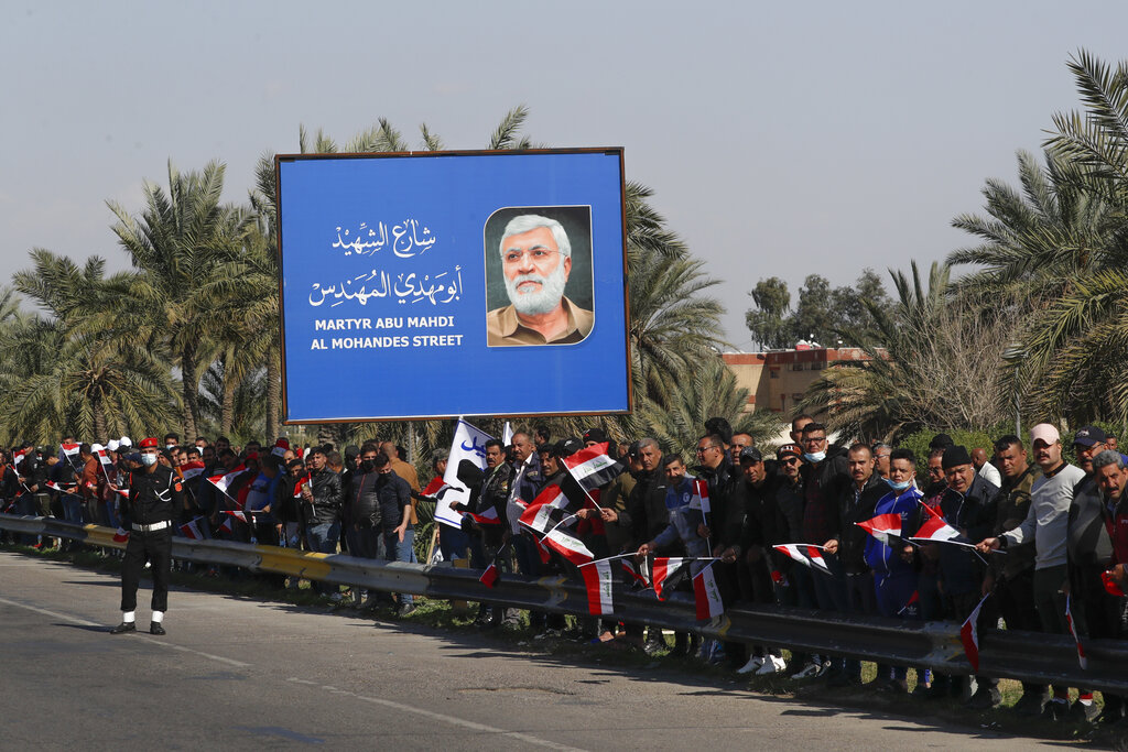 Peoplestand by the road as they wait for Pope Francis to pass by, in Baghdad Iraq, Friday, March 5, 2021. Pope Francis has arrived in Iraq to urge the country's dwindling number of Christians to stay put and help rebuild the country after years of war and persecution, brushing aside the coronavirus pandemic and security concerns. (AP Photo/Andrew Medichini)