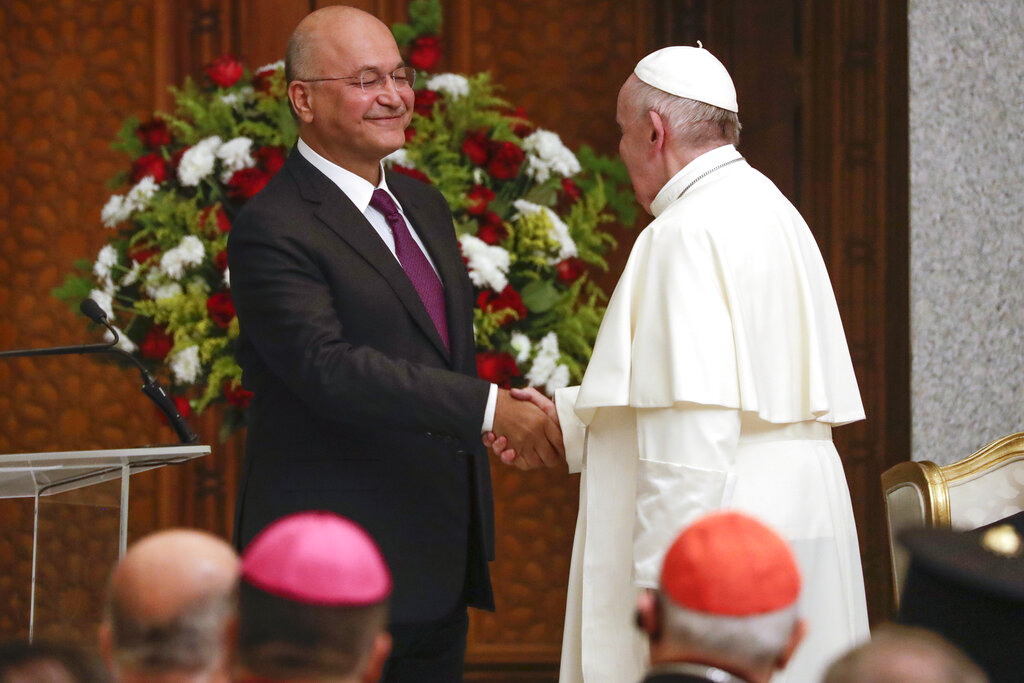 Pope Francis and Iraqi President Barham Salih shake hands, at Baghdad's Presidential Palace, Iraq, Friday, March 5, 2021. Pope Francis has arrived in Iraq to urge the country's dwindling number of Christians to stay put and help rebuild the country after years of war and persecution, brushing aside the coronavirus pandemic and security concerns. (AP Photo/Andrew Medichini)