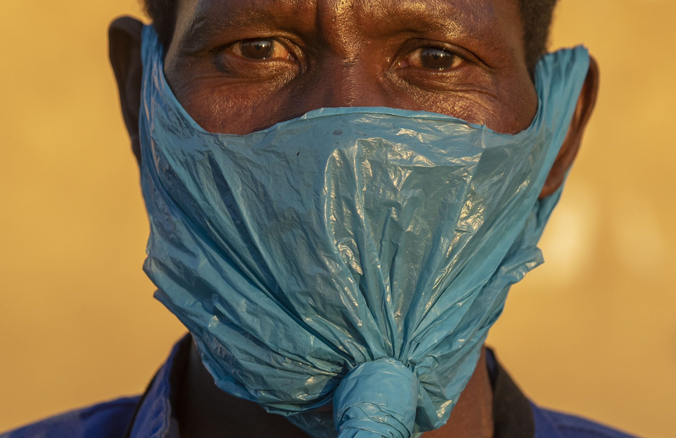 Uomo con mascherina di plastica a Johannesburg, in Sud Africa (AP Photo/Themba Hadebe)