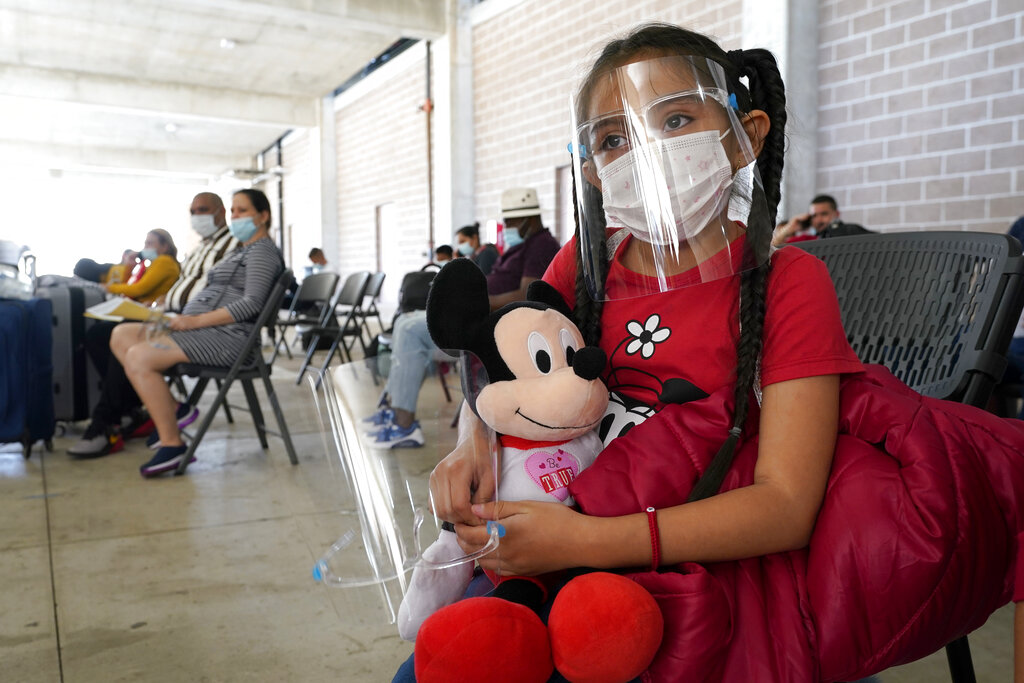 Genesis Cuellar, 8, a migrant from El Salvador, sits in a waiting area to be processed by Team Brownsville, a humanitarian group, helping migrants released from U.S. Customs and Border Protection custody, Wednesday, March 17, 2021, in Brownsville, Texas. The group will facilitate travel so that Cuellar, who is traveling with her mother, Ana Icela Cuellar, can be reunited with her her brother, Andy Nathanael, 4, and their father Marvin Giovani Perez Bonilla, who have been residing in Maryland after being released from custody. The Cuellar family separated in August of 2020, when they tried to cross the U.S.-Mexico border. A surge of migrants on the Southwest border has the Biden administration on the defensive. The head of Homeland Security acknowledged the severity of the problem Tuesday but insisted it's under control and said he won't revive a Trump-era practice of immediately expelling teens and children. (AP Photo/Julio Cortez)