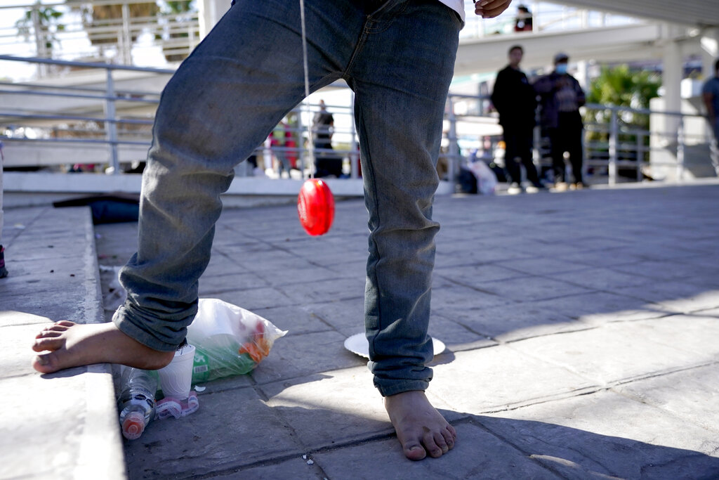 Luis Miguel Fajardo, 10, a migrant from El Salvador who was caught trying to sneak into the United States and deported, is barefoot as he plays with a yoyo at a plaza near a point of entry into the U.S., Thursday, March 18, 2021, in Reynosa, Mexico. A surge of migrants on the Southwest border has the Biden administration on the defensive. The head of Homeland Security acknowledged the severity of the problem Tuesday but insisted it's under control and said he won't revive a Trump-era practice of immediately expelling teens and children. (AP Photo/Julio Cortez)