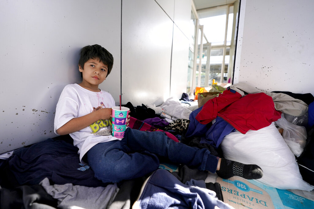 Miguel David Fajardo, 8, a migrant from Honduras, rests at a plaza near the McAllen-Hidalgo International Bridge point of entry into the United States after he, his 13-year-old brother and their mother were caught trying to sneak into the U.S. and deported, Thursday, March 18, 2021, in Reynosa, Mexico. A surge of migrants on the Southwest border has the Biden administration on the defensive. The head of Homeland Security acknowledged the severity of the problem Tuesday but insisted it's under control and said he won't revive a Trump-era practice of immediately expelling teens and children. (AP Photo/Julio Cortez)