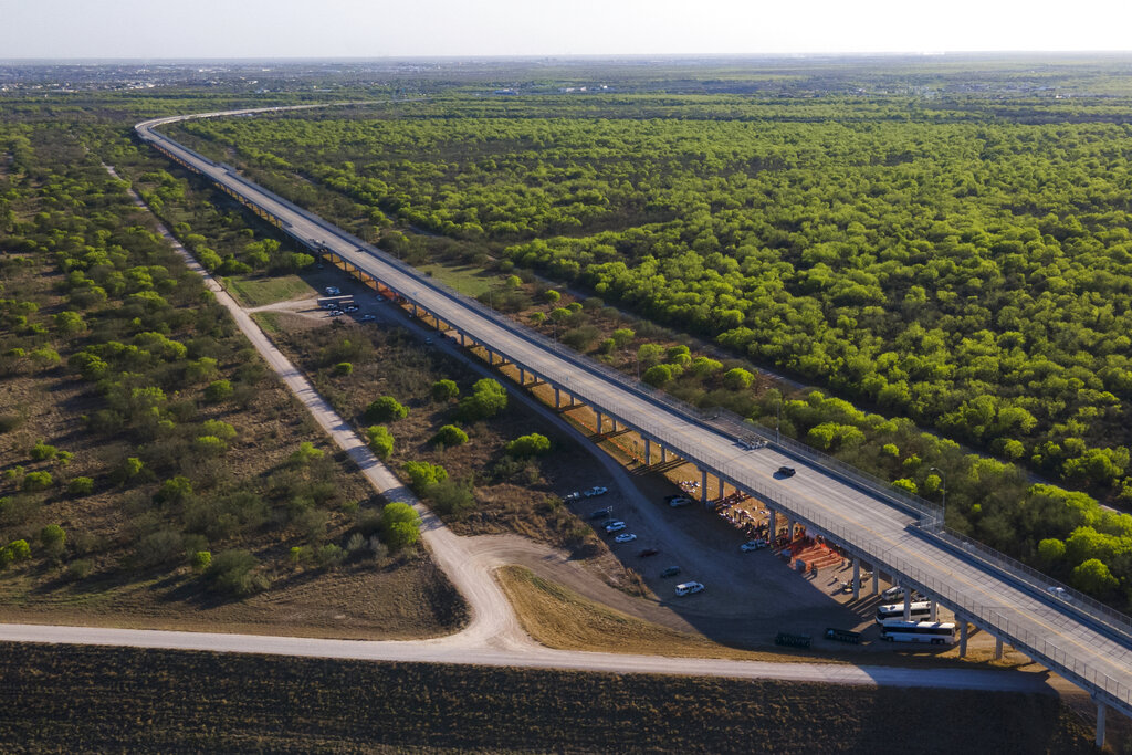 In this photo taken by a drone, a U.S. Customs and Border Protection processing area is seen under the Anzalduas International Bridge, Thursday, March 18, 2021, in Mission, Texas. A surge of migrants on the Southwest border has the Biden administration on the defensive. The head of Homeland Security acknowledged the severity of the problem Tuesday but insisted it's under control and said he won't revive a Trump-era practice of immediately expelling teens and children. (AP Photo/Julio Cortez)