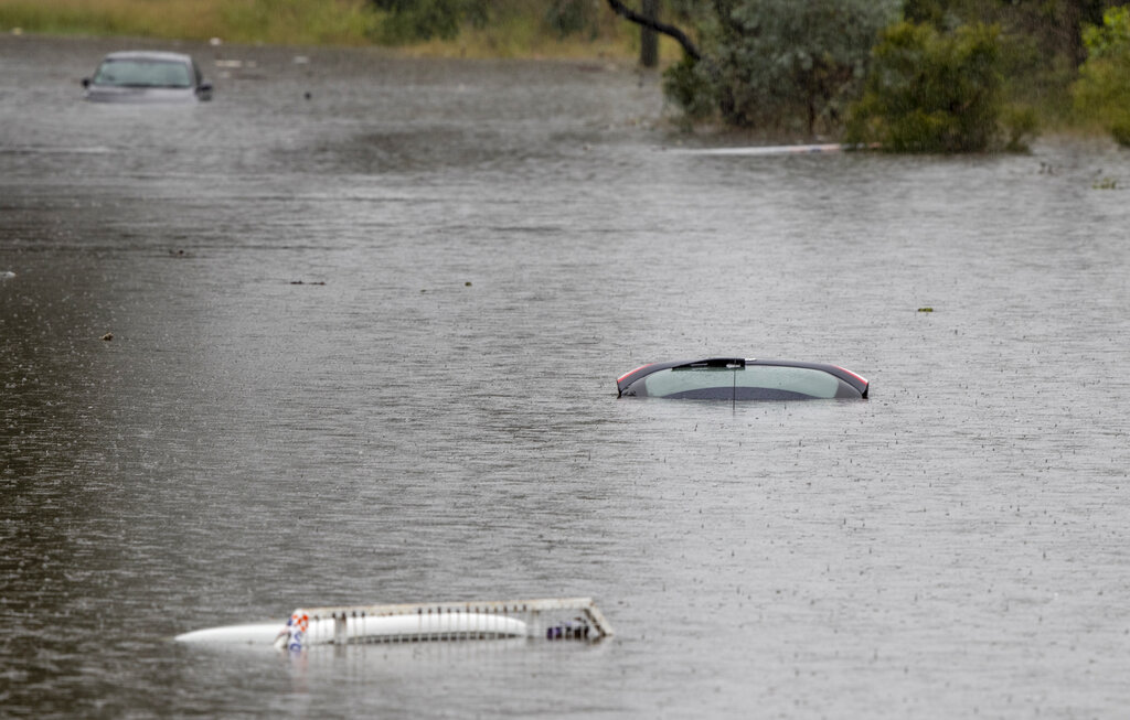 Vehicles are submerged in a flooded yard near Londonderry on the western outskirts of Sydney, Australia, Monday, March 22, 2021. Hundreds of people have been rescued from floodwaters that have isolated dozens of towns in Australia's most populous state of New South Wales and forced thousands to evacuate their homes as record rain continues to inundate the countries east coast. (AP Photo/Mark Baker)