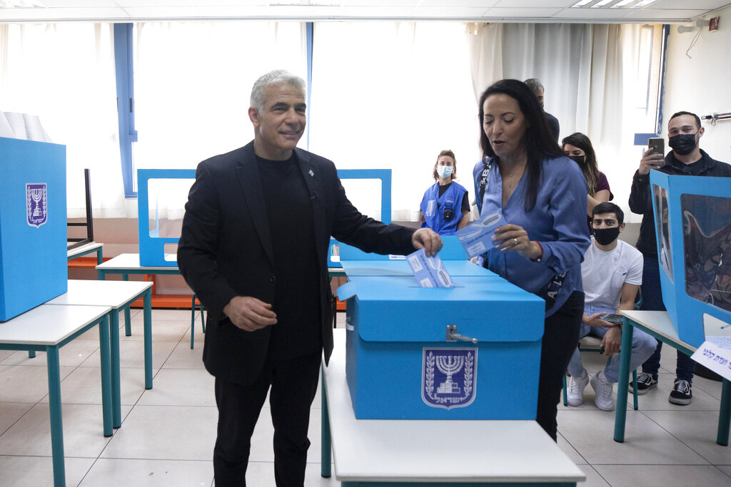 Yesh Atid party leader Yair Lapid and his wife Lihi vote for Israel's parliamentary election at a polling station in Tel Aviv, Israel, Tuesday, March. 23, 2021. Israel is holding its fourth election in less than two years. (AP Photo/Sebastian Scheiner)