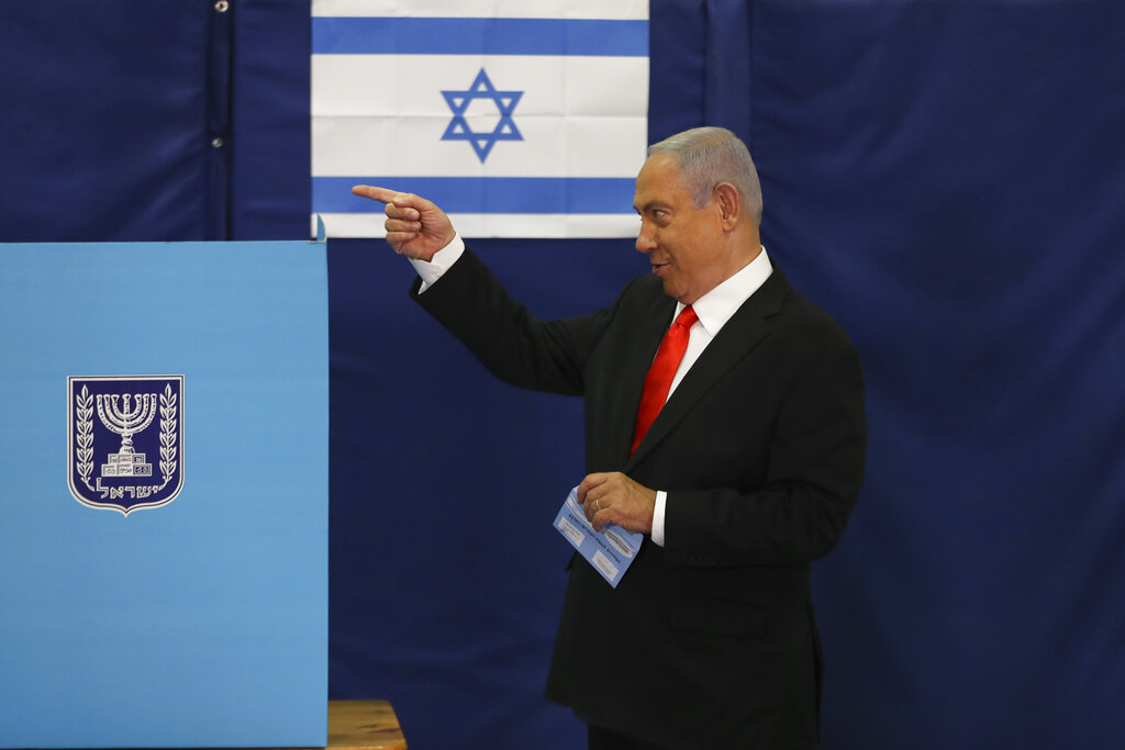 Israeli Prime Minister Benjamin Netanyahu prepares to cast his ballot at a polling station as Israelis vote in a general election, in Jerusalem, Tuesday, March 23, 2021. Israelis began voting on Tuesday in the country's fourth parliamentary election in two years — a highly charged referendum on the divisive rule of  Netanyahu. (Ronen Zvulun/Pool via AP)