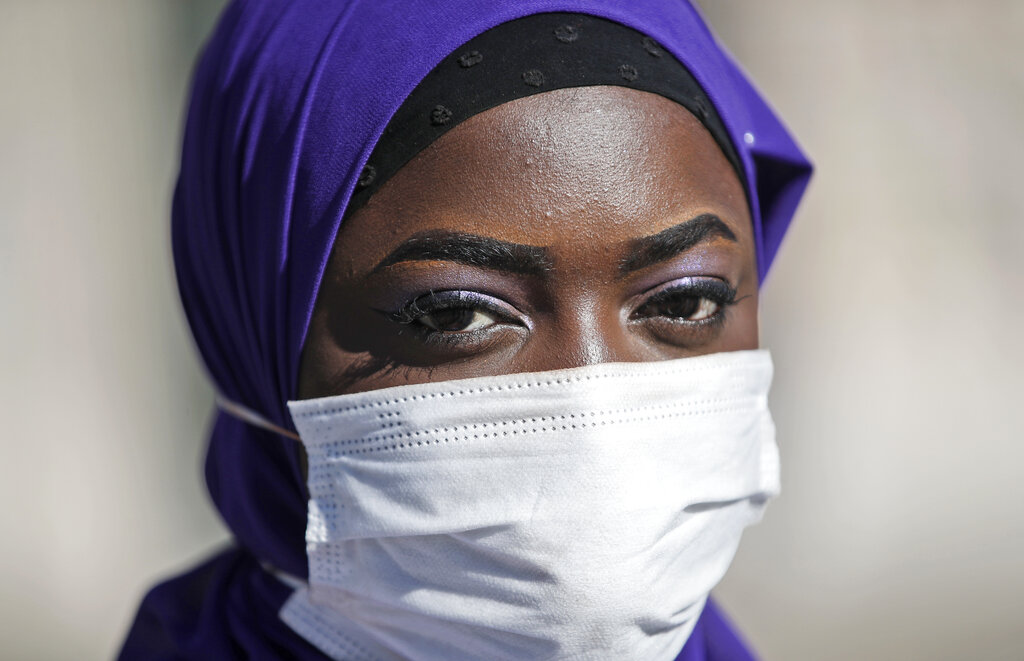 Influencer Aida Diouf Mbengue wears a face mask to curb the spread of COVID-19 as she poses for a portrait, in Milan, Italy, Tuesday, March 16, 2021. Mbengue, 19, from Senegal, is making a name for herself as a self-billed Afro-Influencer, one of a group of young people in Italy of African origin who have come together to try to increase their influence in social media. (AP Photo/Antonio Calanni)
