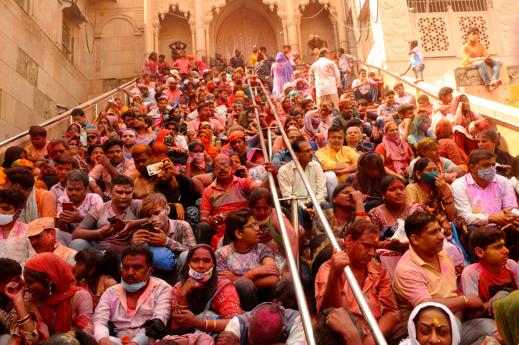 Hindu devotees sit on the steps of Radha temple at the legendary hometown of Radha, consort of Hindu God Krishna, during Lathmar holi, in Barsana, 115 kilometers (71 miles) from New Delhi, India, Tuesday, March 23, 2021. During Lathmar Holi the women of Barsana beat men from Nandgaon, the hometown of Krishna, with wooden sticks in response to their teasing (AP Photo)