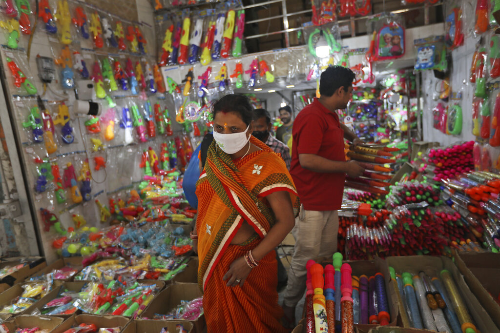 People shop for water guns ahead of Holi, the Hindu festival of colors, in New Delhi, India, Thursday, March 25, 2021. (AP Photo/Manish Swarup)