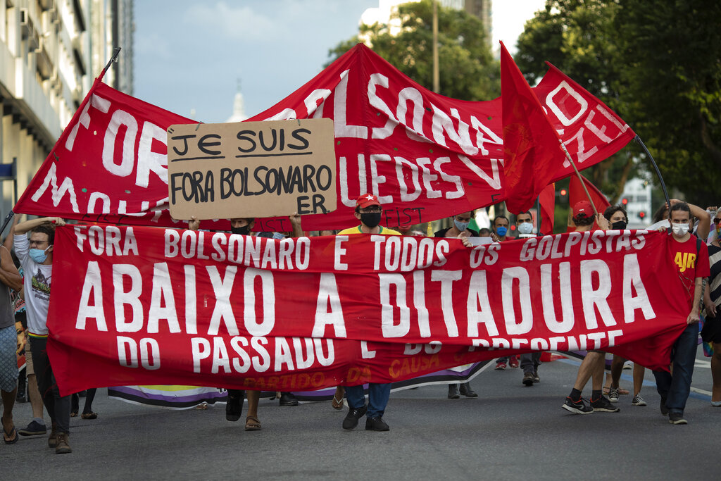 Demonstrators hold a banner with a message that reads in Portuguese: 