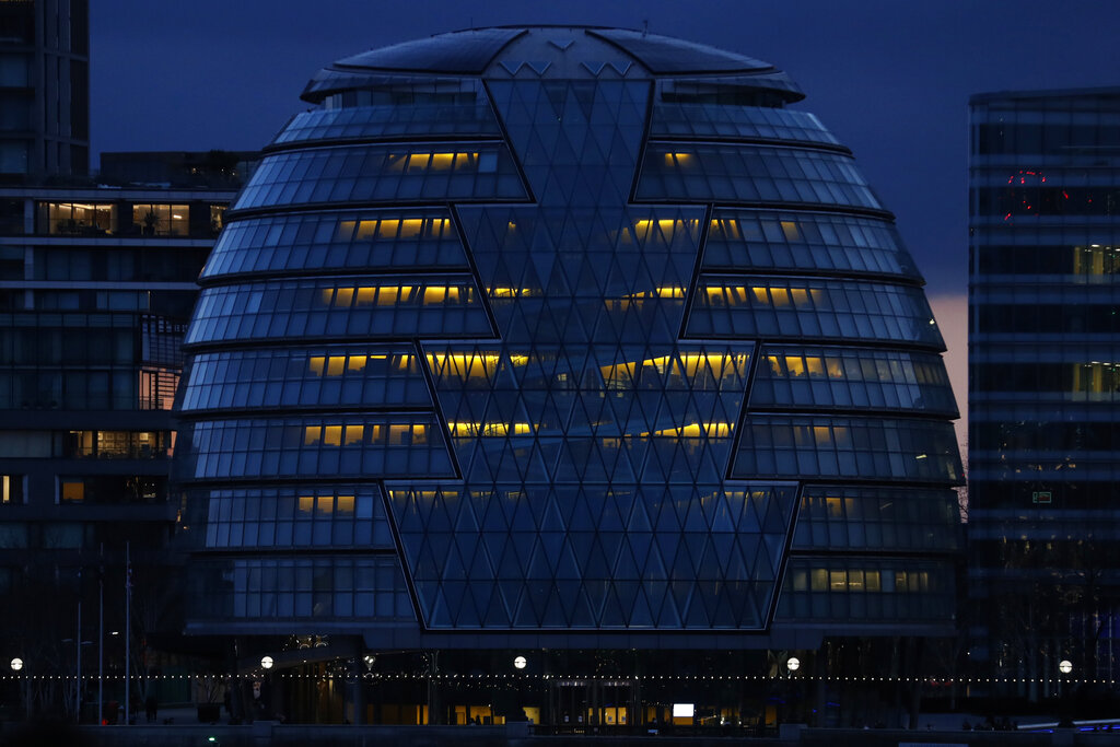 City Hall on the south bank of the Thames in London is illuminated in the evening of Saturday, March 6, 2021. (AP Photo/Alastair Grant)