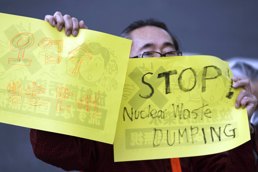 A man holds placards that read 