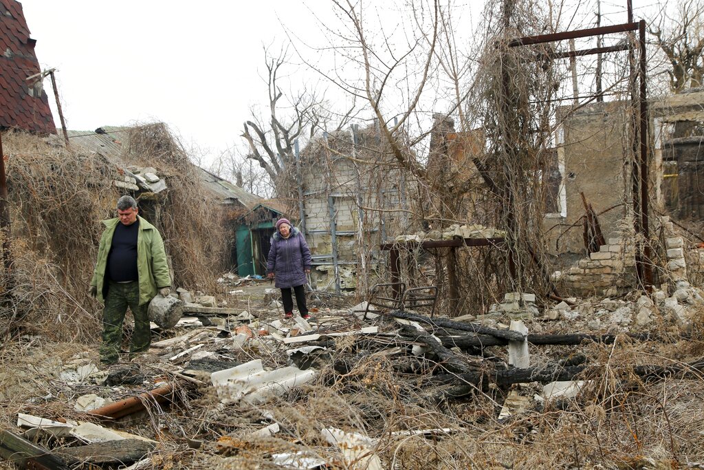 Local citizens visit their home in the separatist-controlled territory to collect belongings after a recent shelling near a frontline outside Donetsk, eastern Ukraine, Friday, April 9, 2021 .Tensions have built up in recent weeks in the area of the separatist conflict in eastern Ukraine, with violations of a cease-fire becoming increasingly frequent. (AP Photo)