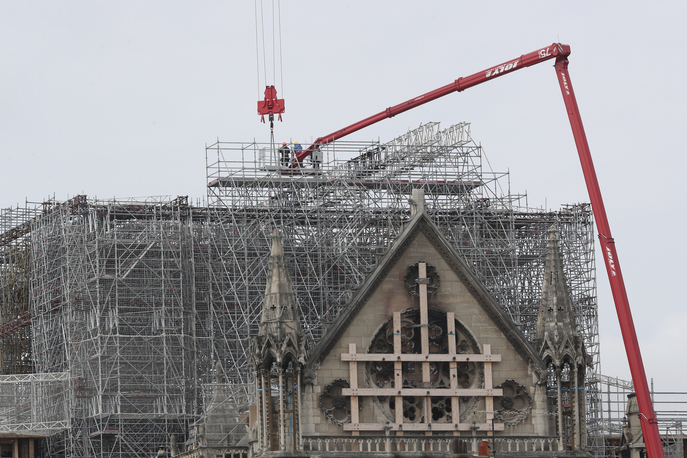 Workers start removing the scaffolding at Notre Dame cathedral, Monday, June 8, 2020 in Paris. Workers suspended from ropes will be lowered into the charred remains of scaffolding that melted atop Notre Dame when the cathedral went up in flames and begin the delicate job of dismantling the 200 tons of metal. (AP Photo/Thibault Camus)