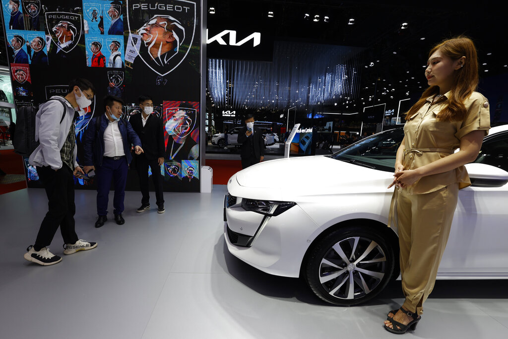 Visitors look at the latest cars on display during the Shanghai Auto Show in Shanghai on Monday, April 19, 2021. Automakers are looking to China, their biggest market by sales volume and the first major economy to rebound from the pandemic, to revive sales and reverse multibillion-dollar losses. (AP Photo/Ng Han Guan)